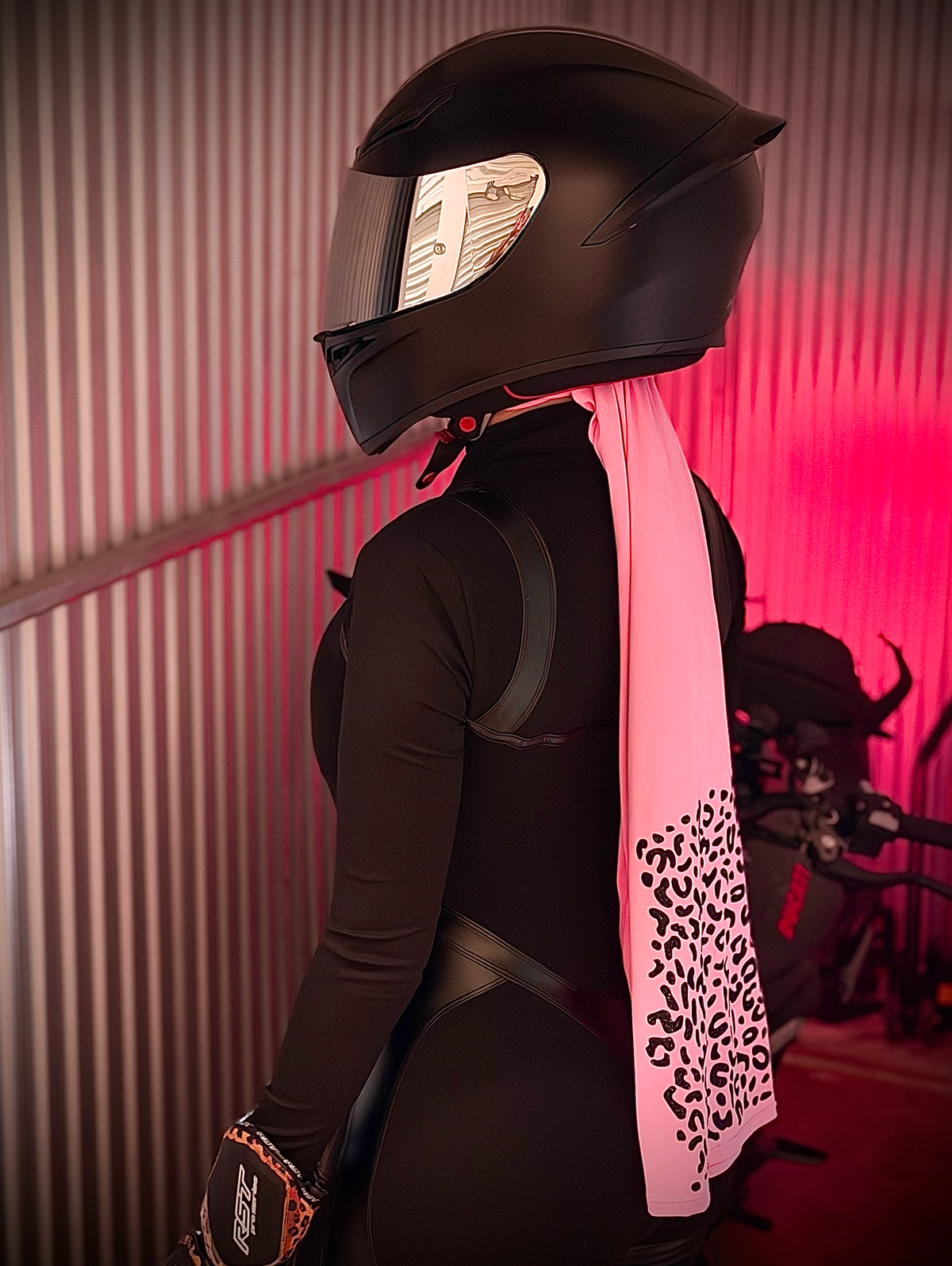 Rider in a black full-face helmet wearing pink leopard Brisa Ride